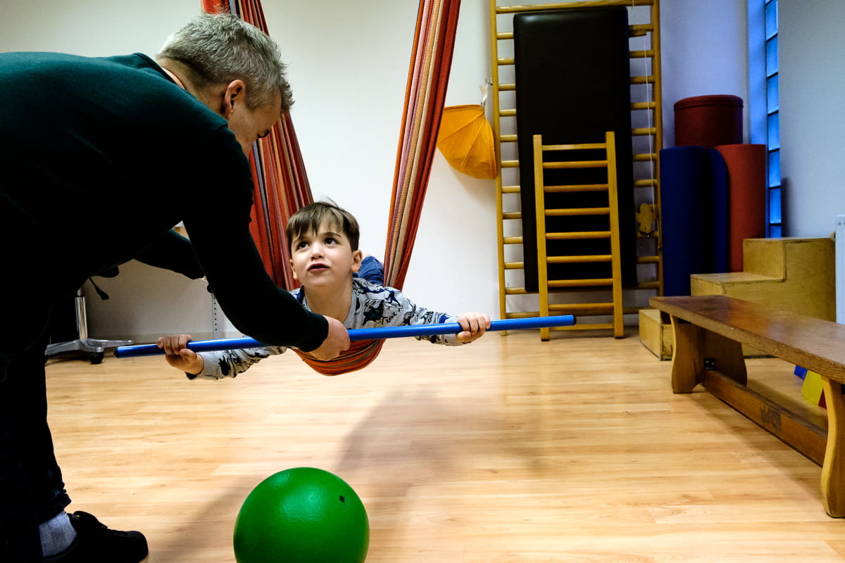 Peter geeft kind instructie in hangmat