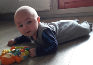 Baby op vloer met voorkeurshouding Baby op vloer met voorkeurshouding